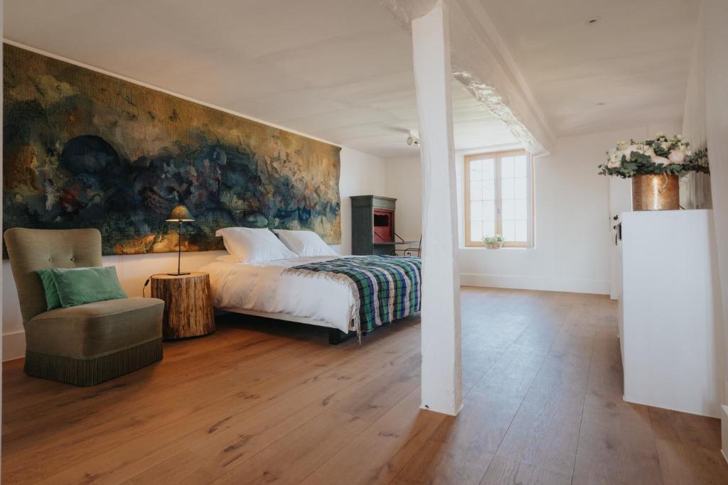 a bedroom with a bed and a painting on the wall at Amitié in Kinrooi