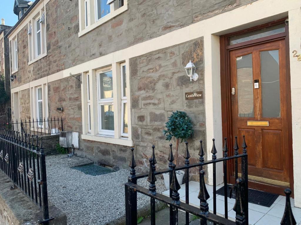 a fence in front of a house with a door at Castle View Accommodation in Inverness