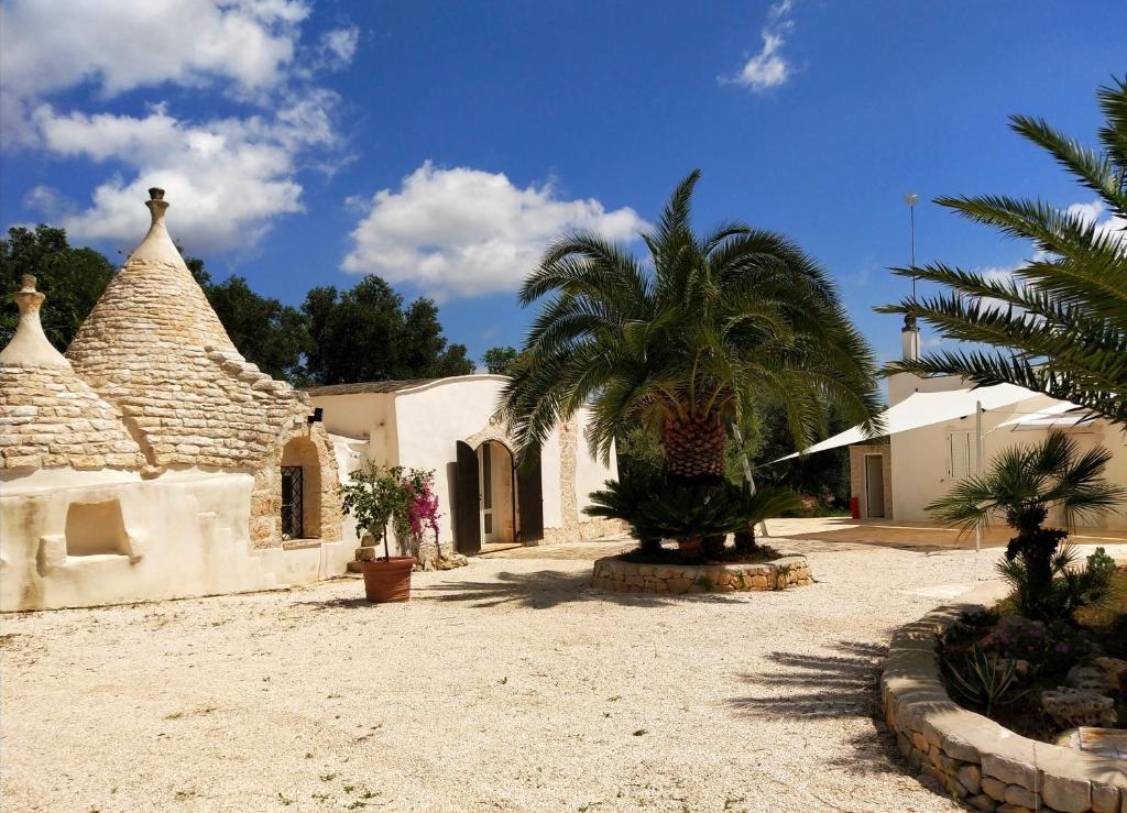 ein Haus mit einer Palme im Hof in der Unterkunft Trullo Felice in Ostuni