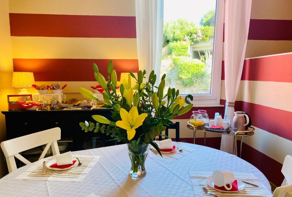 un tavolo con un vaso con fiori gialli di Cá Leon a La Spezia