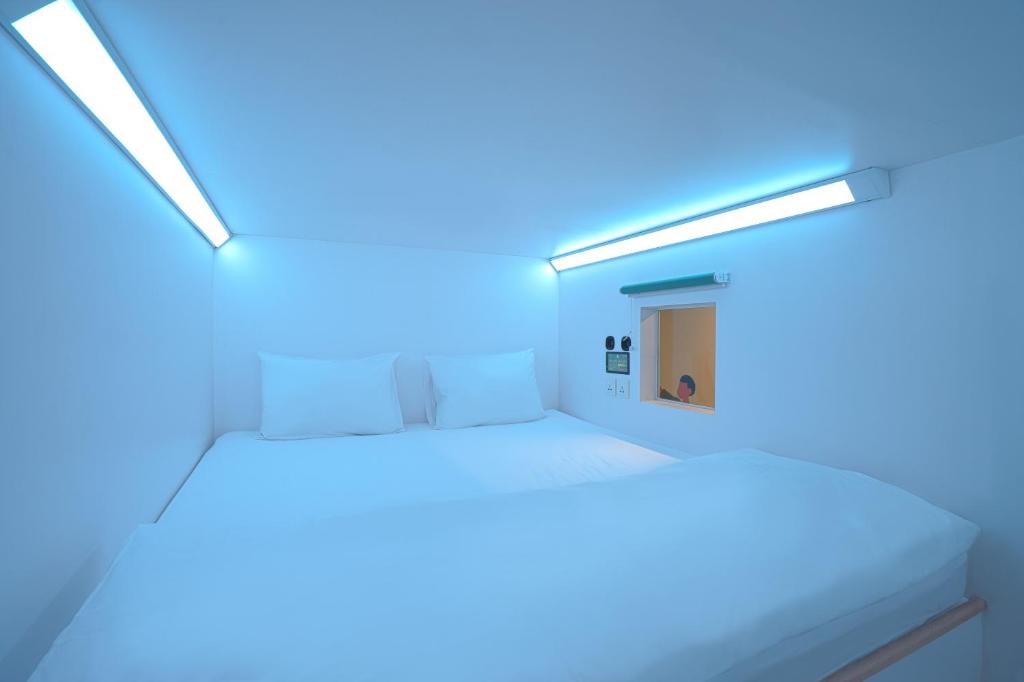 Habitación con cama con luces azules. en Bobopod Pancoran, Jakarta, en Yakarta