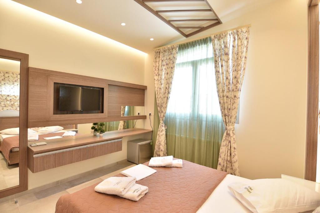 a hotel room with a bed and a television at On Board Luxury Studios in Sarti