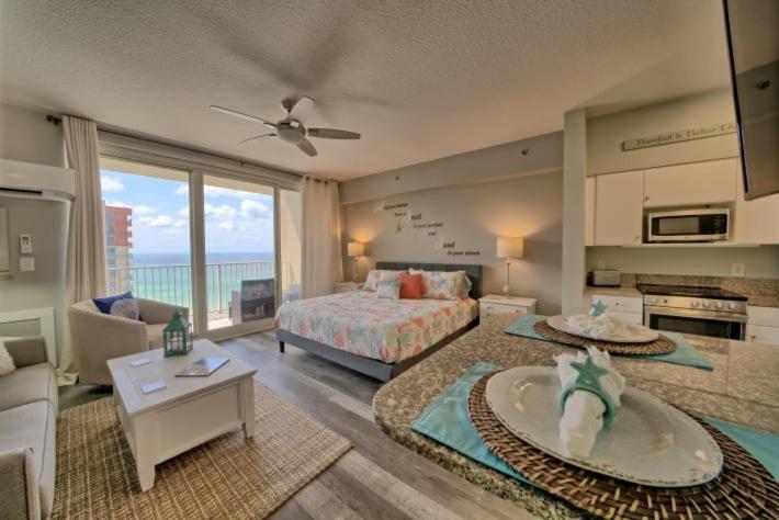 a bedroom with a bed and a living room at Deluxe Beachfront Studio, Shores of Panama New and Renovated in Panama City Beach