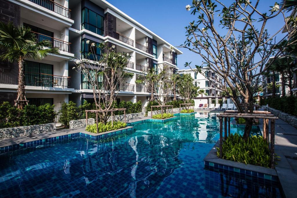 una piscina frente a un edificio en The Title Beach Front en Rawai Beach