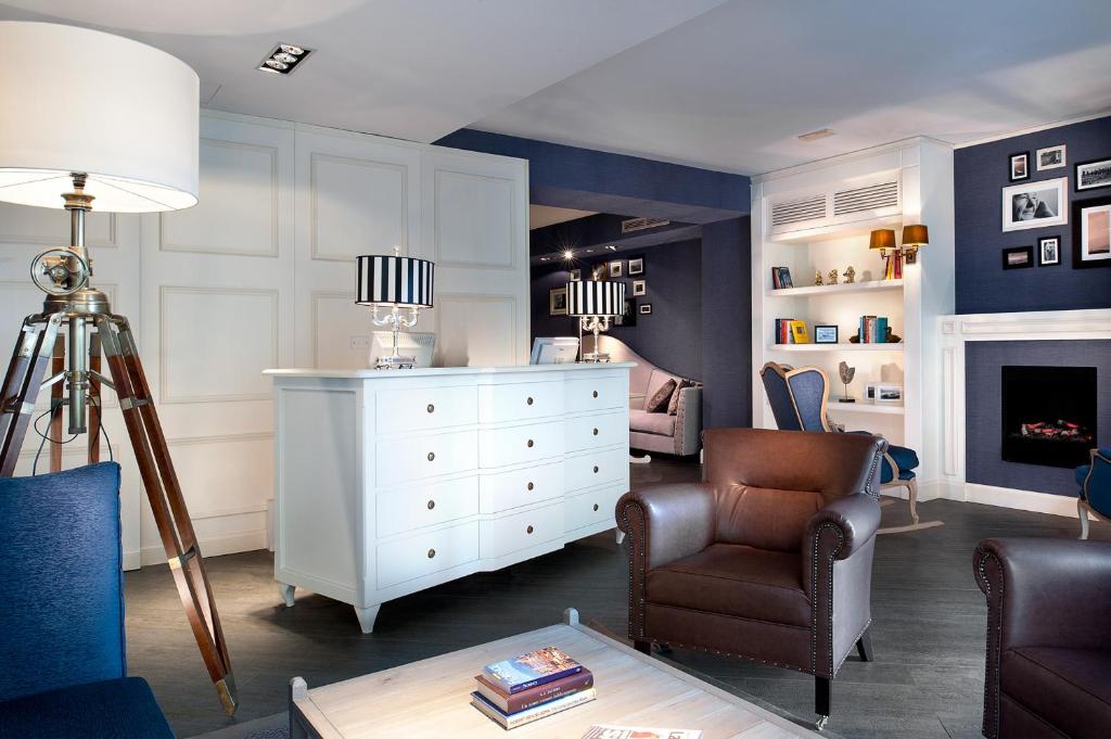 uma sala de estar com uma cómoda branca e uma cadeira em c-hotels Club em Florença