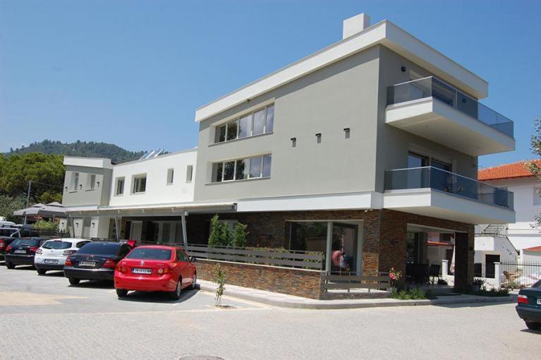 a building with cars parked in a parking lot at On Board Luxury Studios in Sarti