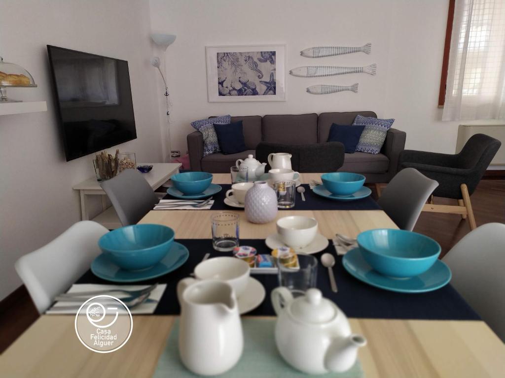 a living room with a table with blue dishes on it at Casa Felicidad Alguer B&B in Alghero
