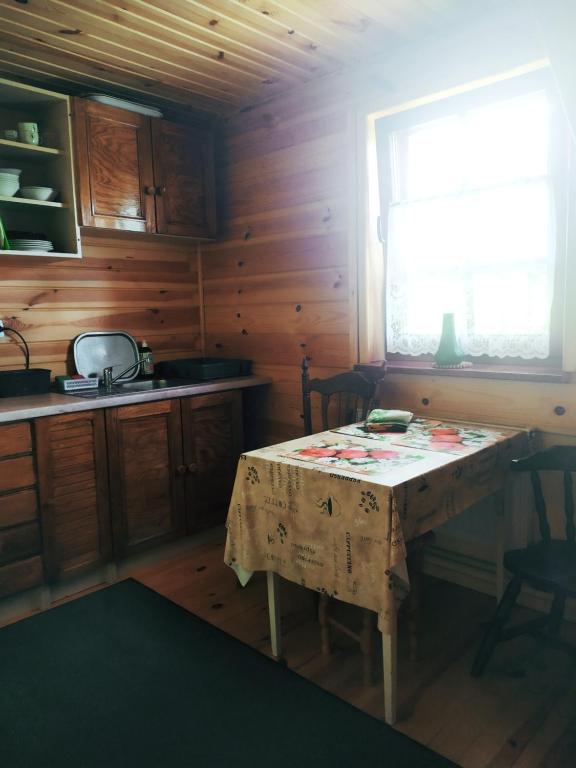 a small kitchen with a table and a window at Borsuki pod Lipą in Sarnaki