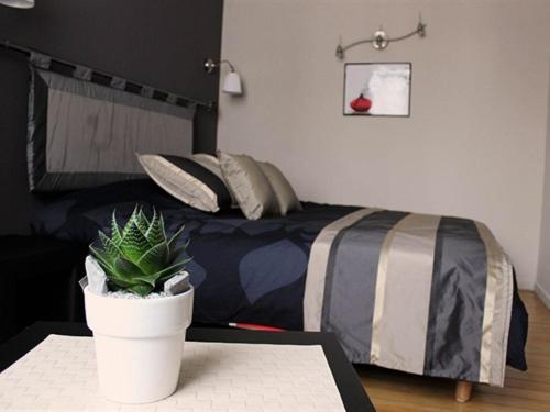 una camera da letto con un letto e una pianta in vaso su un tavolo di Villa Louvre Lens a Lens