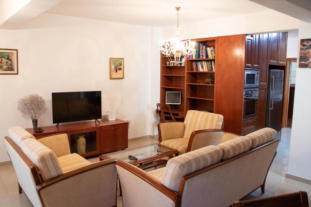 a living room with a couch and a tv at Luxury Apartment, near Pinikoudes beach in Larnaca