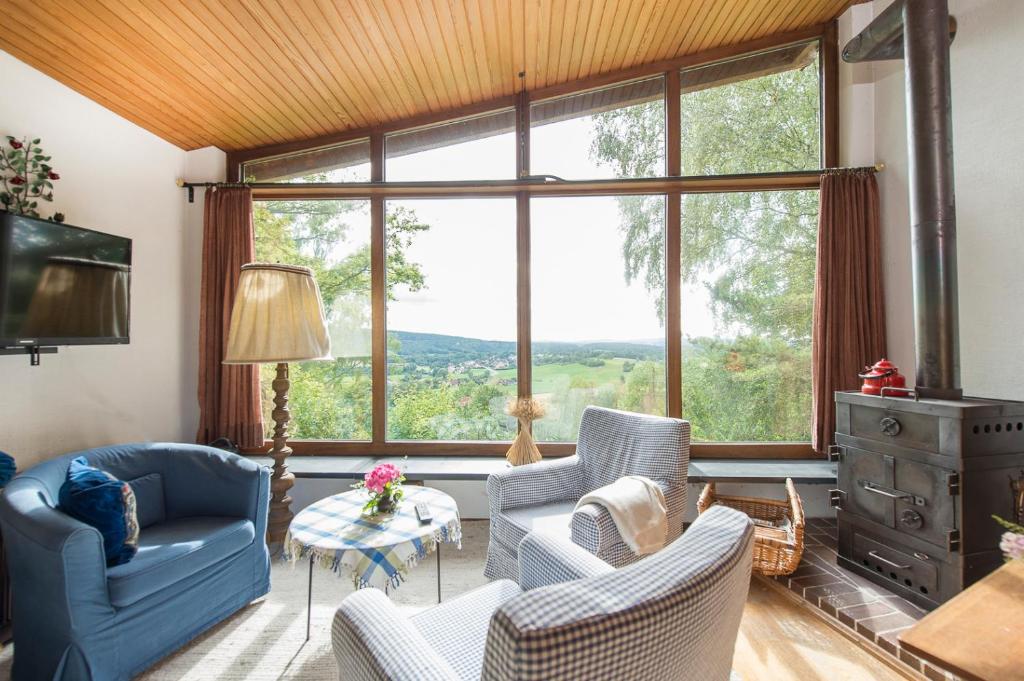 ein Wohnzimmer mit Stühlen und einem großen Fenster in der Unterkunft Ferienhäuschen Sans Pareille bei Bayreuth in Hartmannsreuth