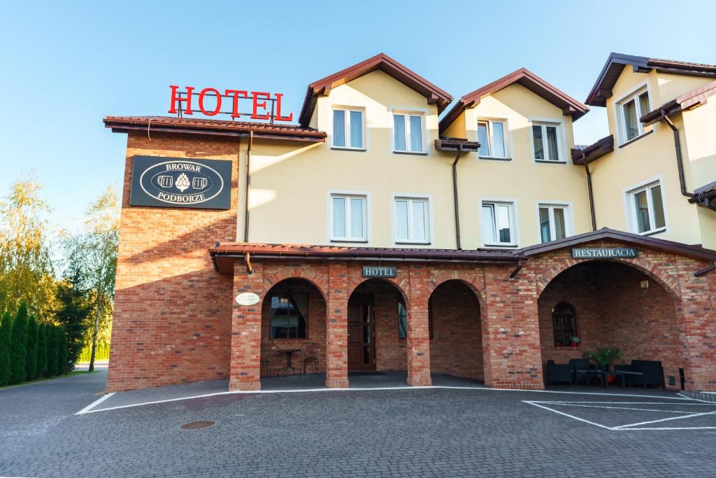 un edificio de hotel con un cartel encima en Dworek Nad Stawem & Łaźnia Piwna, en Ostrów Mazowiecka