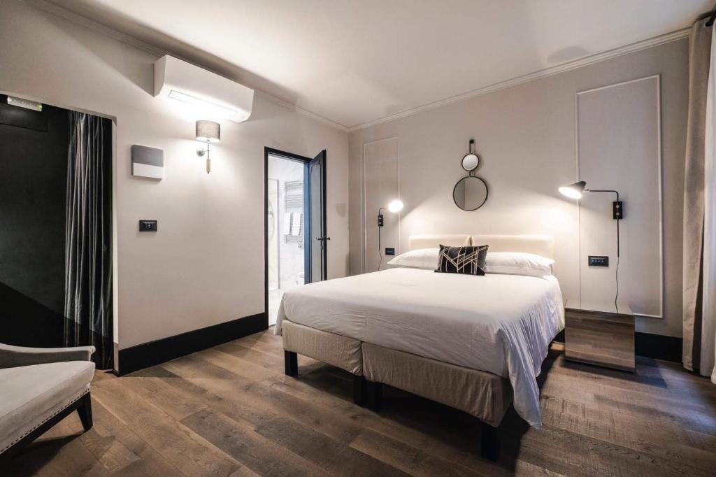 een slaapkamer met een groot wit bed en een raam bij LUXURY SANTO STEFANO in Venetië