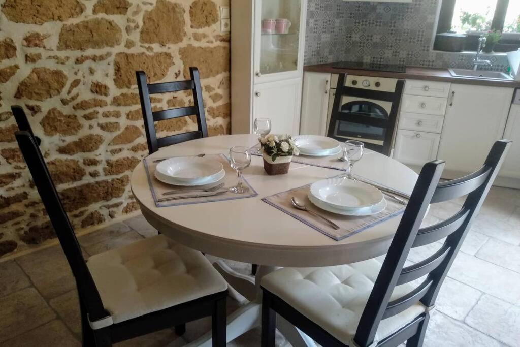 a kitchen with a table with chairs and a tableasteryasteryasteryasteryasteryastery at Traditional stone house in Sitia