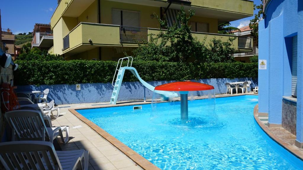 a plunge pool with a red slide in a building at Hotel Albatros in Roseto degli Abruzzi
