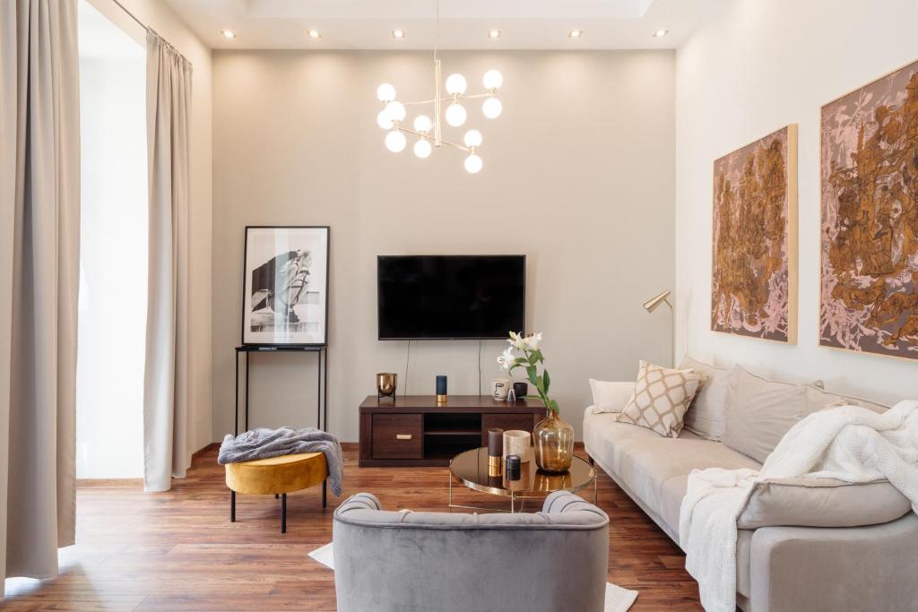 Una sala de estar con un sofá y un televisor. en Boho Lofts - LoftAffair, en Cracovia