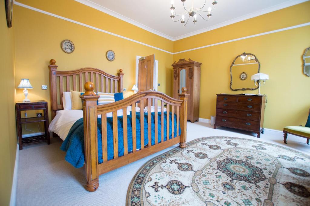 1 dormitorio con cuna y vestidor en The Portland Guesthouse en Cheltenham