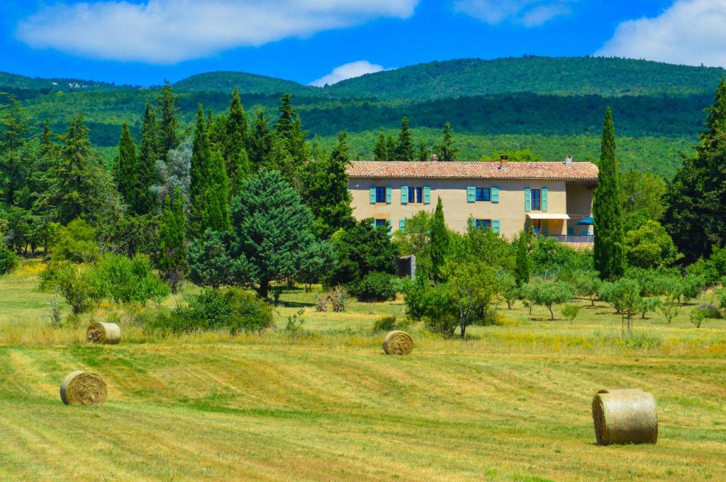 una casa en un campo con fardos de heno en La Bastide Du Claus - Vitaverde, en Cruis