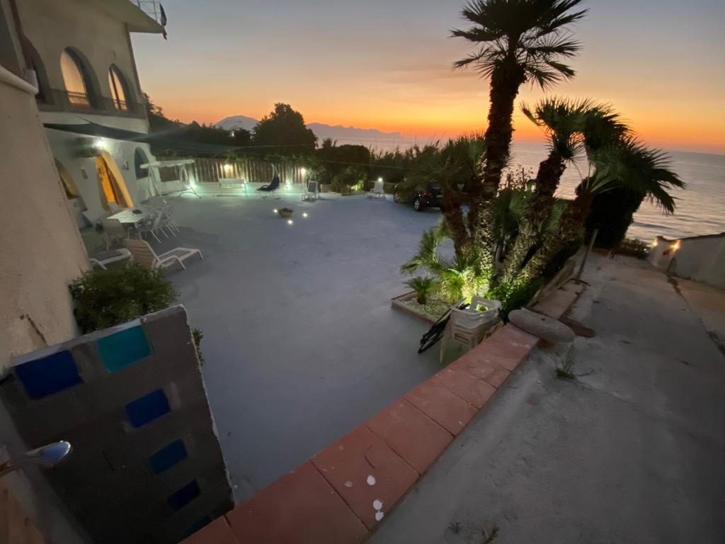 - une vue sur la piscine bordée d'un palmier dans l'établissement Villa Heraclea sul mare, à Trappeto