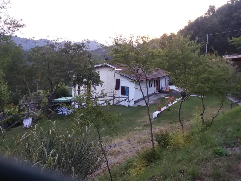 ein Haus inmitten eines Feldes mit Bäumen in der Unterkunft B&B la Casa del daino in Millesimo