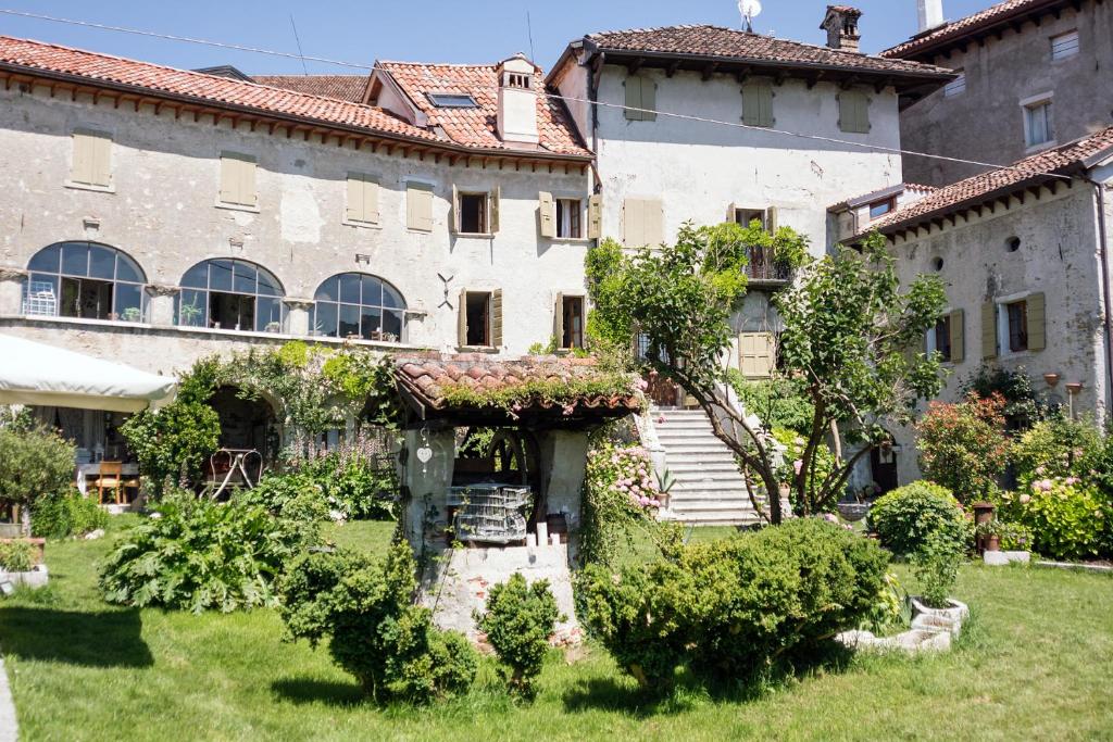 un ancien bâtiment avec un jardin en face de celui-ci dans l'établissement Villa Francescon, à Belluno