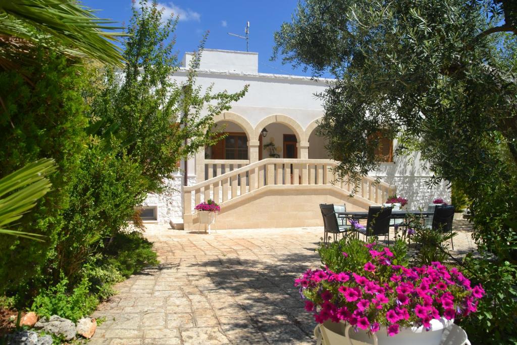 a house with a patio and flowers in front of it at Agriturismo Salinola in Ostuni