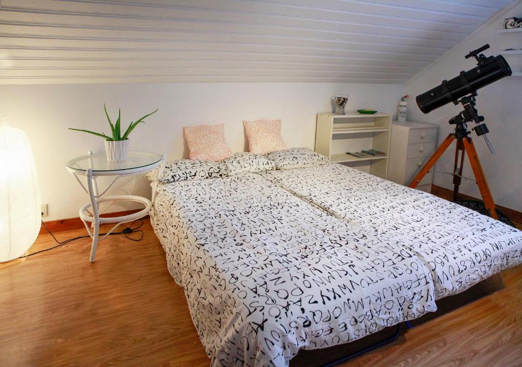 1 dormitorio con 1 cama con una cámara en un trípode en The Cozy Little House, en Motala