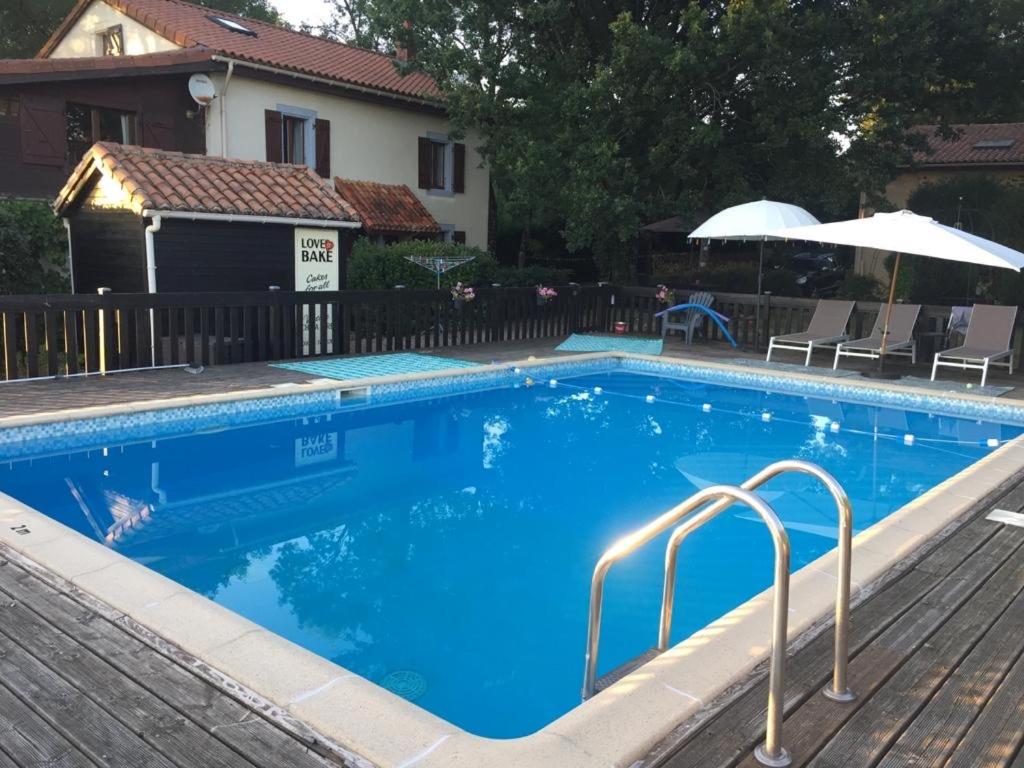 une grande piscine bleue à côté d'une maison dans l'établissement Maison L’allee, à Lézignac-Durand