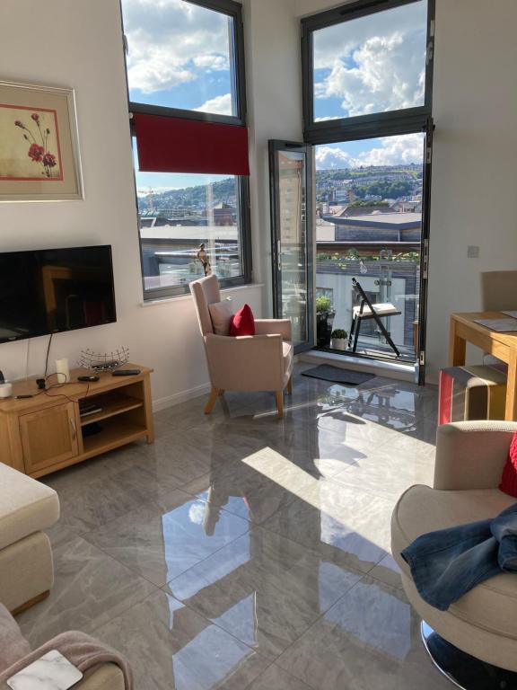 a living room with large windows and a television at SWANSEA MARINA VIEW mins to beach, Marina, Swansea Arena, City free parking in Swansea