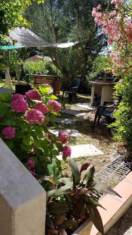 um jardim com flores, uma mesa e um piano em Loft dans cadre de verdure em Ceyreste