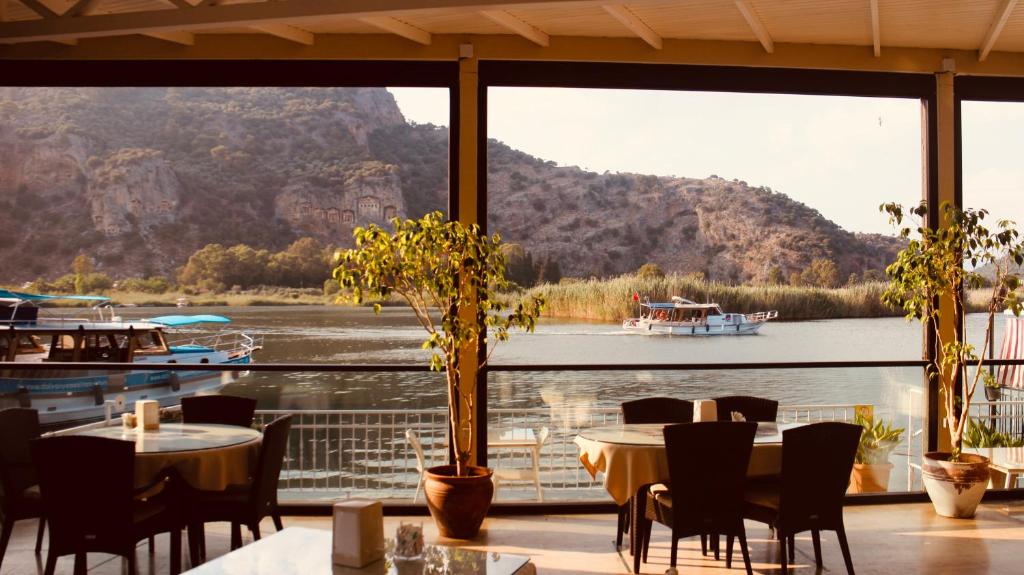 a restaurant with tables and chairs and a view of a river at Arp Dalyan in Dalyan