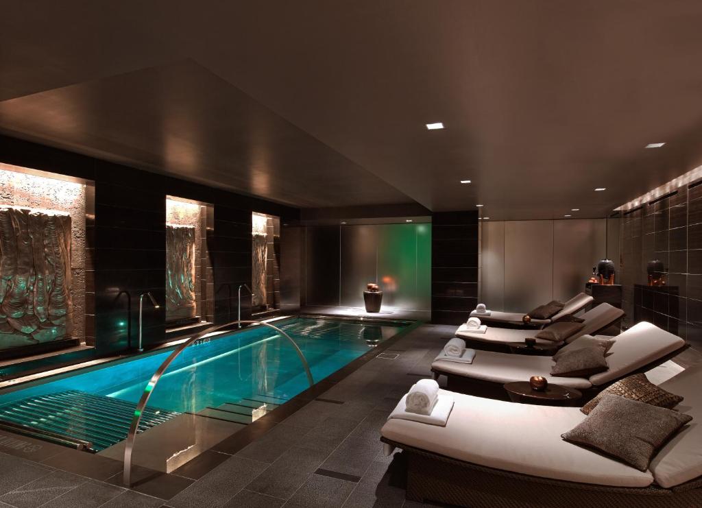 a swimming pool in a hotel with couches and chairs at The Joule in Dallas