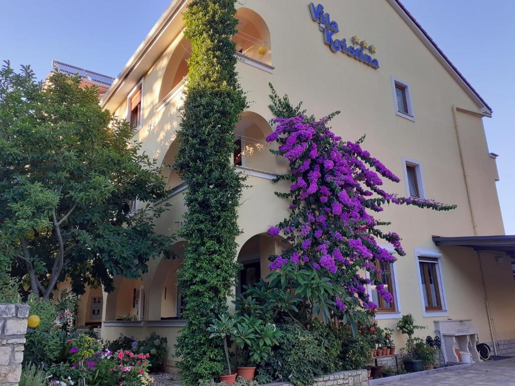 un bâtiment avec des fleurs violettes sur son côté dans l'établissement Villa Kristina, à Rovinj