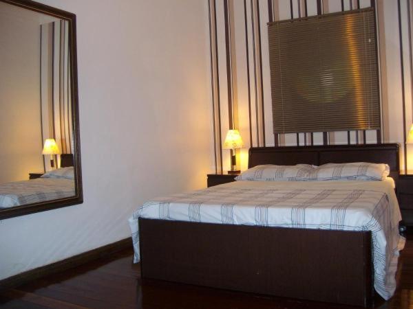 1 dormitorio con cama y espejo grande en Apartamento com Hidro en Belo Horizonte