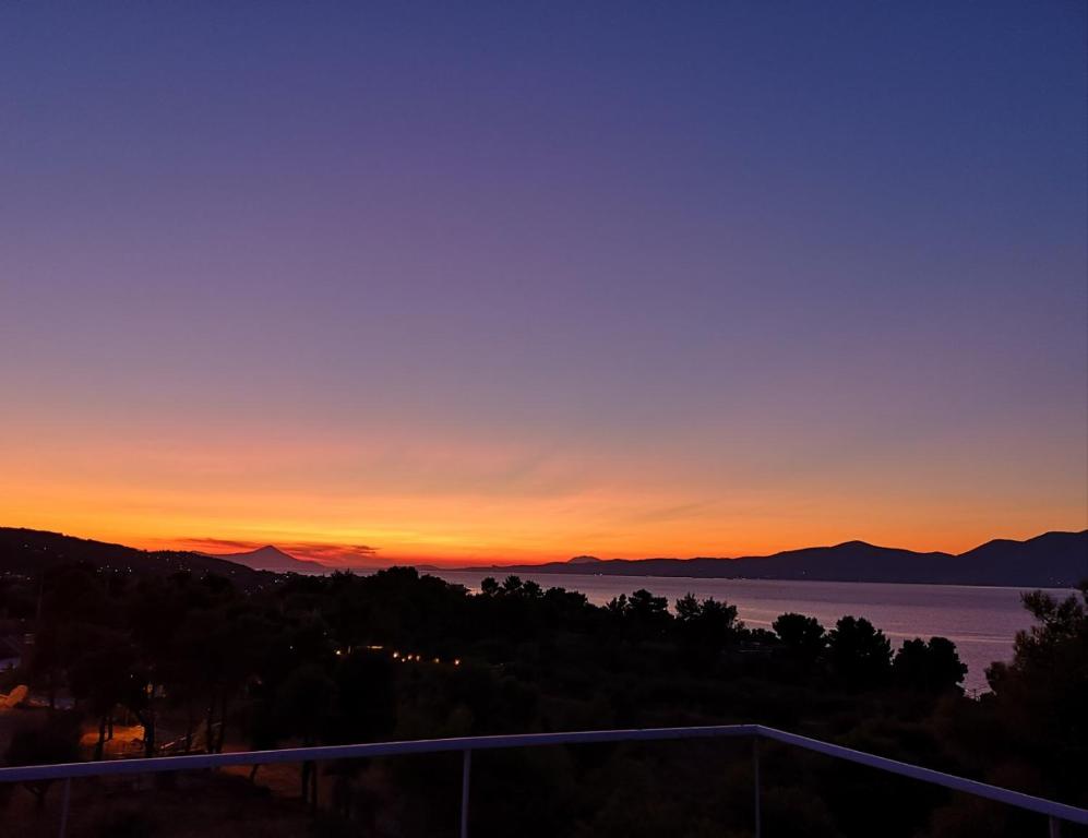 a view of the sunset from the balcony of a house at Panorama View Apartment 1 in Áyioi Apóstoloi