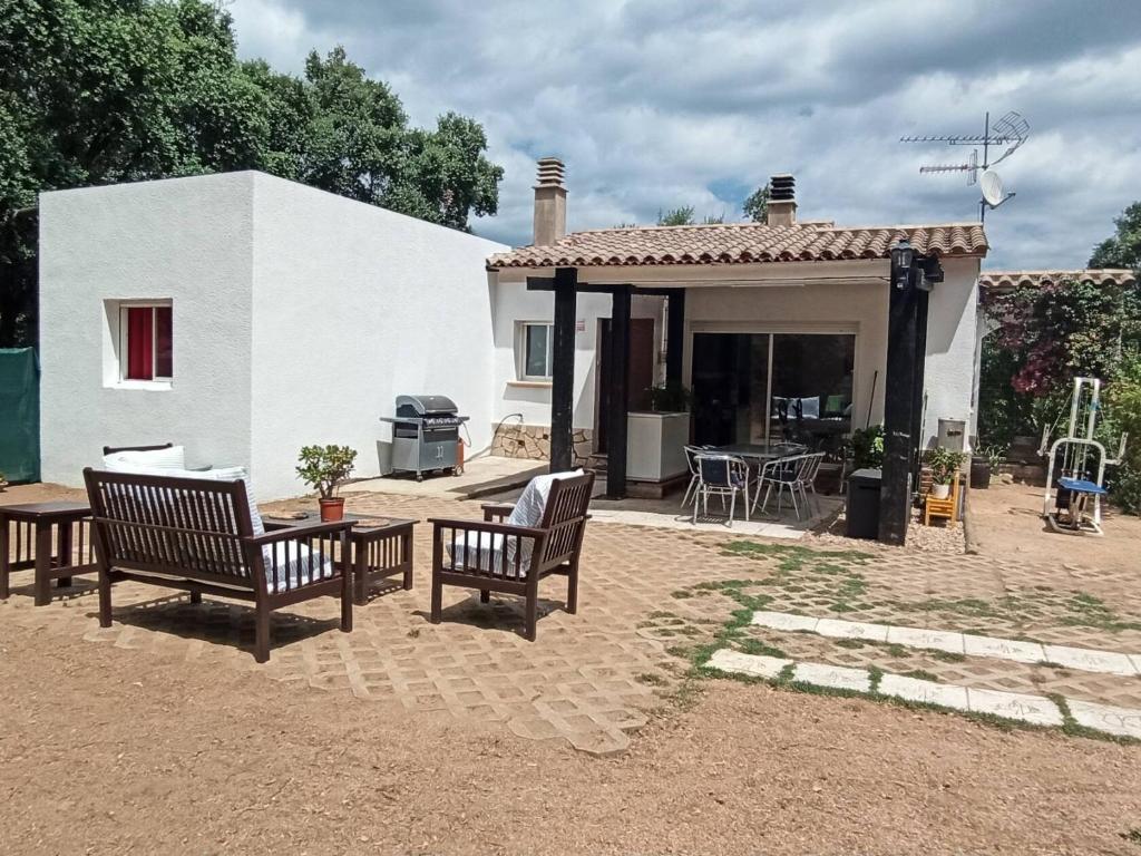 een huis met een patio met stoelen en een tafel bij Chalet en entorno Natural de la Costa Brava in Bell-Lloch