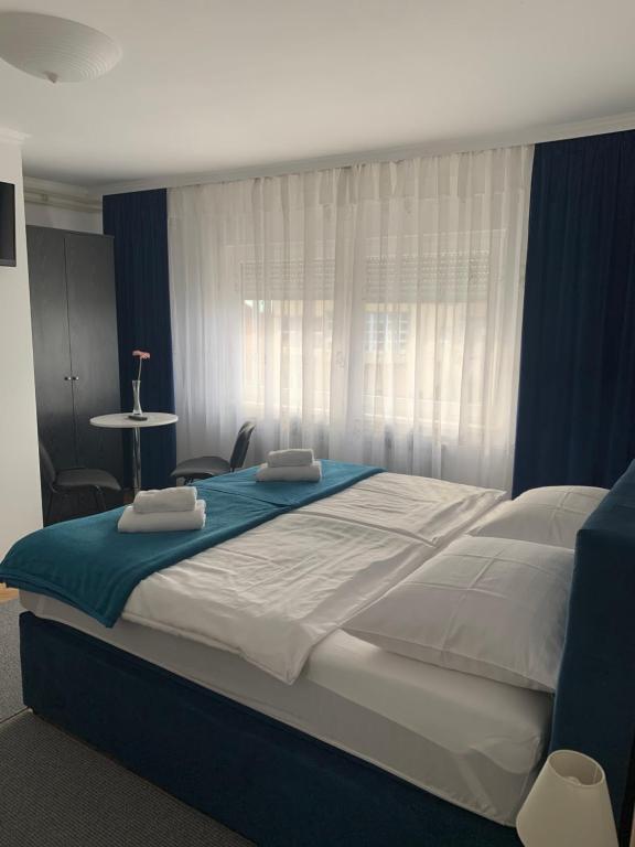 1 dormitorio con 1 cama grande con sábanas azules y blancas en Rooms Stella, en Sesvete