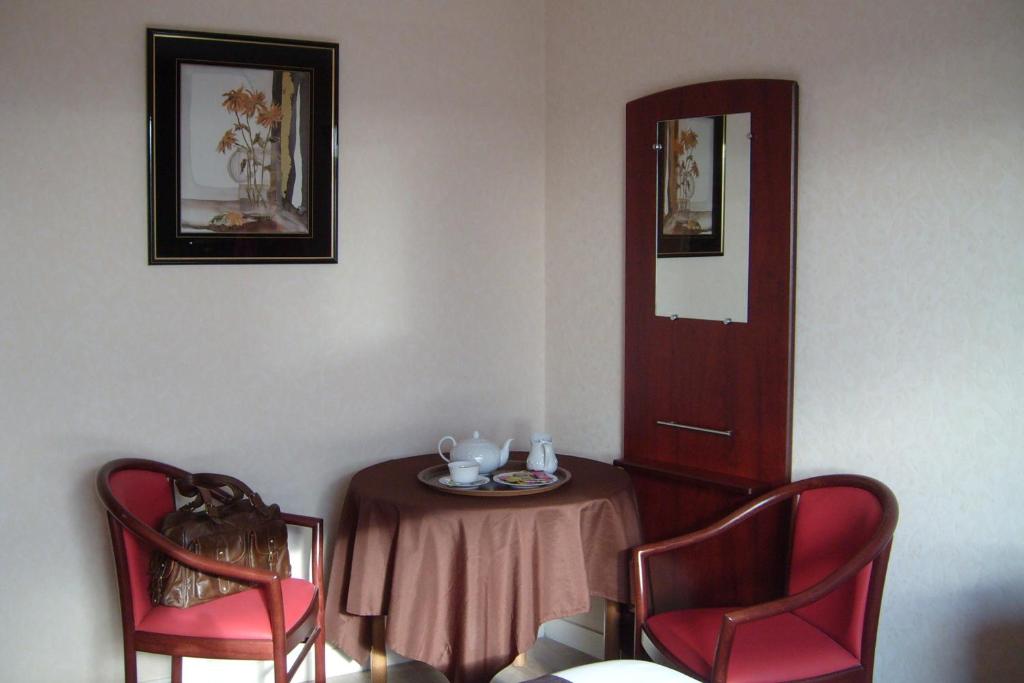 a room with a table and two red chairs at Cit&#39;Hotel Saint Jacques in Parthenay