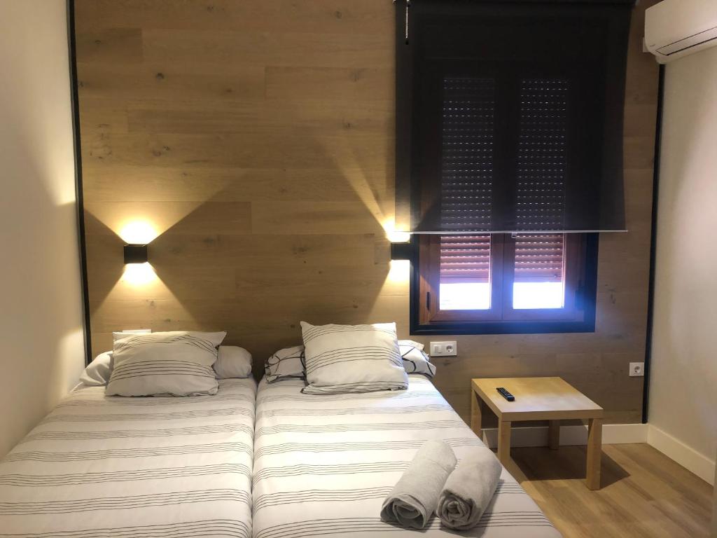 プラセンシアにあるLa Capital del Jerteのベッドルーム1室(ベッド2台、テーブル、窓付)