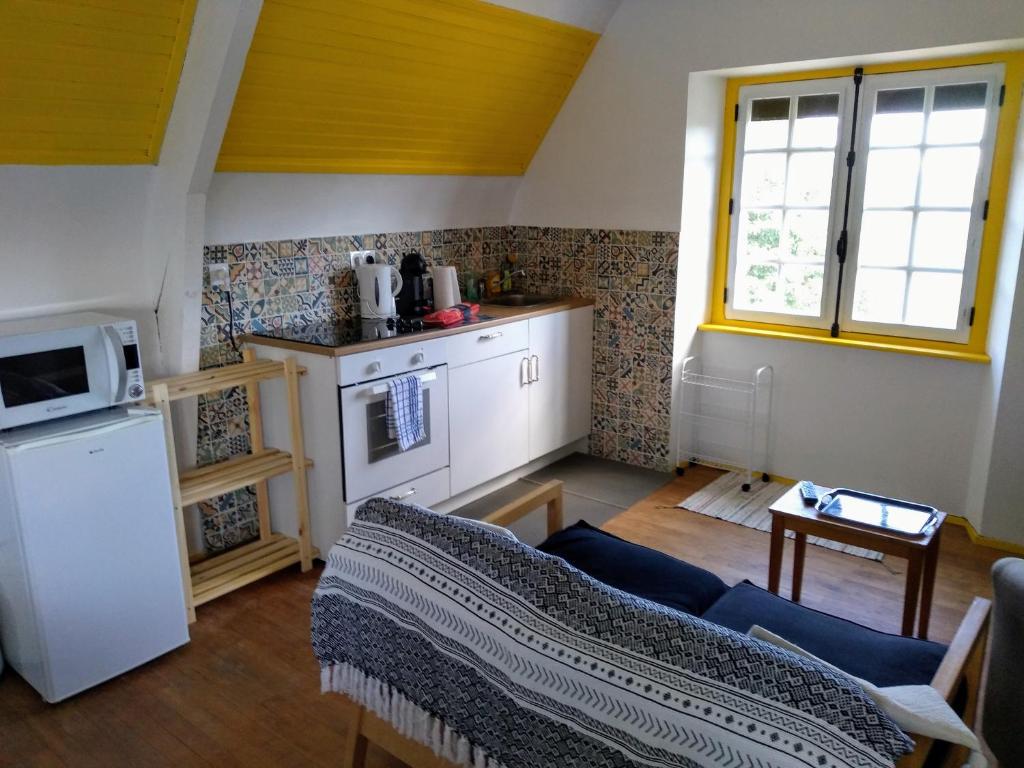 ein Wohnzimmer mit einem Sofa und einer Küche in der Unterkunft Roz Melen in Châteauneuf-du-Faou