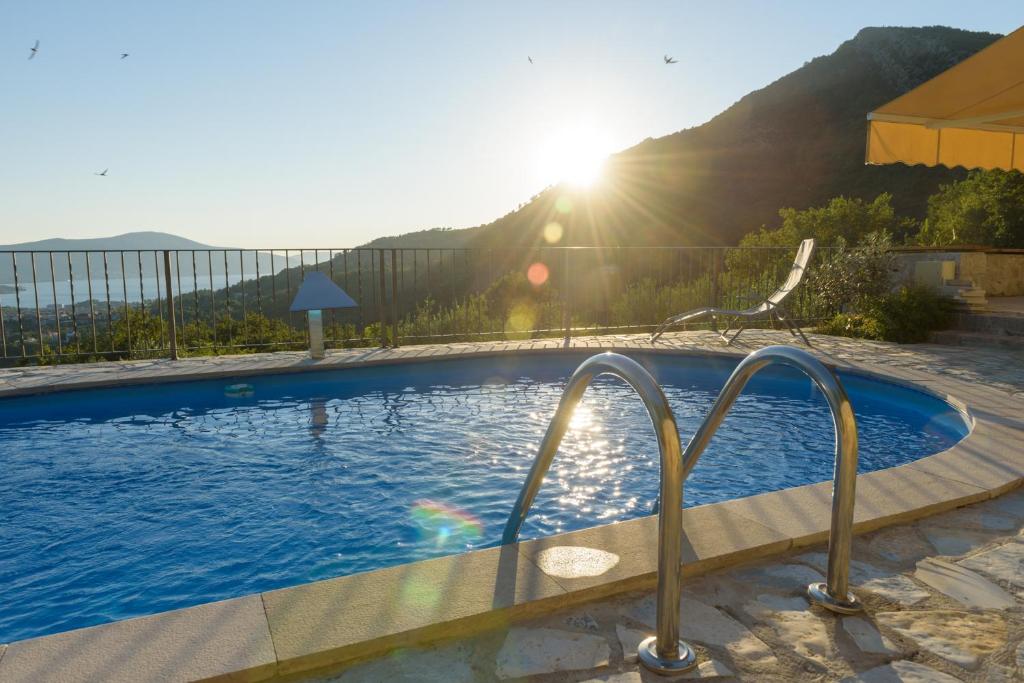 a swimming pool with a view of the mountains at Sunset Holiday Home in Tivat