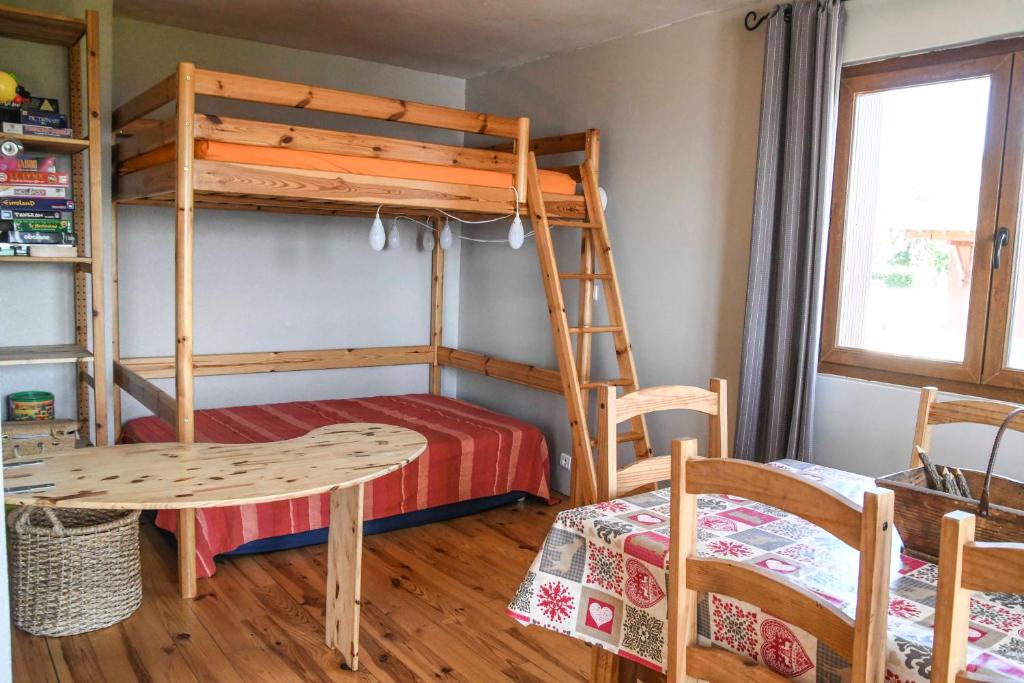 een slaapkamer met een stapelbed en een tafel en stoelen bij Superbe appartement Font Romeu La Pardallera in Font Romeu Odeillo Via