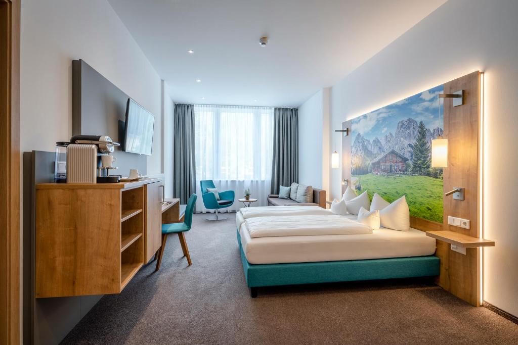 um quarto de hotel com uma cama e uma secretária em AVALON Hotel Bad Reichenhall em Bad Reichenhall