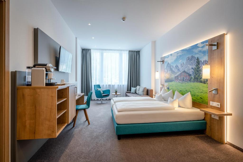 a hotel room with a bed and a desk at AVALON Hotel Bad Reichenhall in Bad Reichenhall