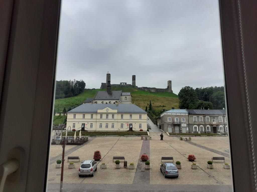 - une vue sur un bâtiment avec des voitures garées dans une cour dans l'établissement Apartament na Rynku, à Chęciny