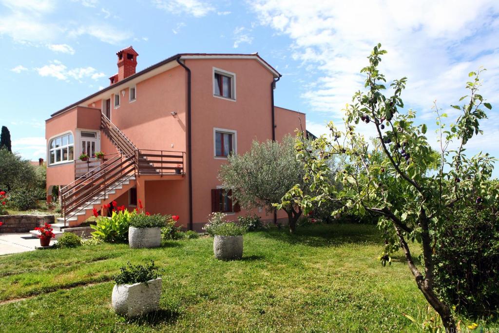 een huis met een grasveld ervoor bij Apartmaji ORKO s pogledom na morje - Sea View Apartments ORKO in Portorož