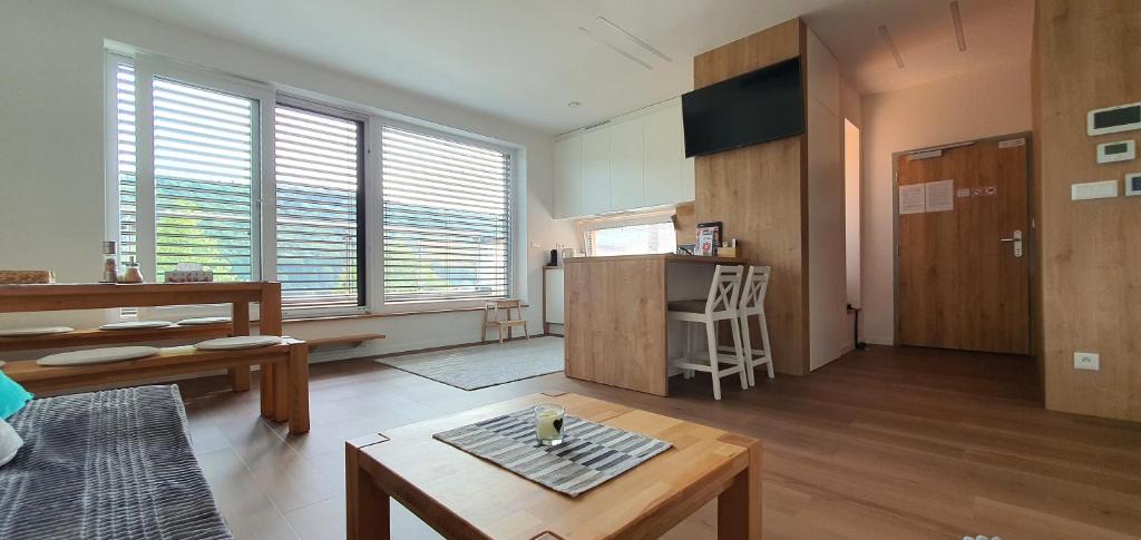 a living room with a coffee table and a kitchen at Penthouse apartmán Minerál B-4 in Bardejovské Kúpele