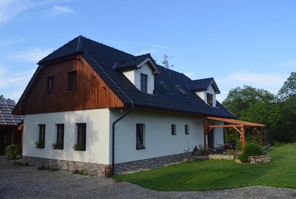 a house with a gambrel roof at Penzion pod Čeřinkem in Mirošov
