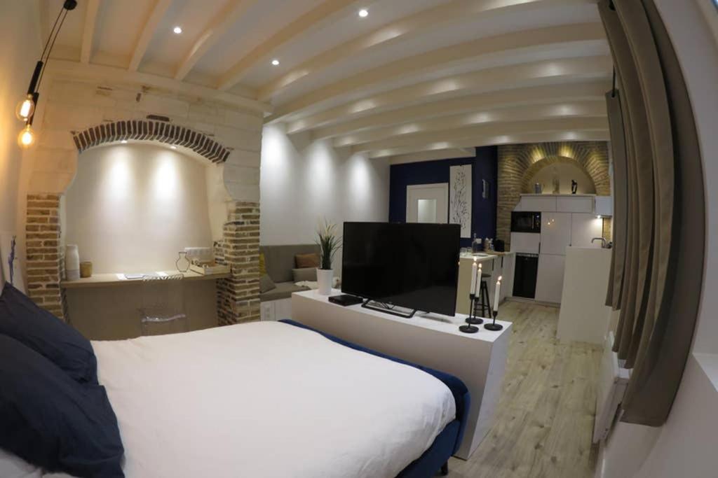 1 dormitorio con 1 cama blanca y cocina en CHARMANT STUDIO HYPER CENTRE, en Troyes