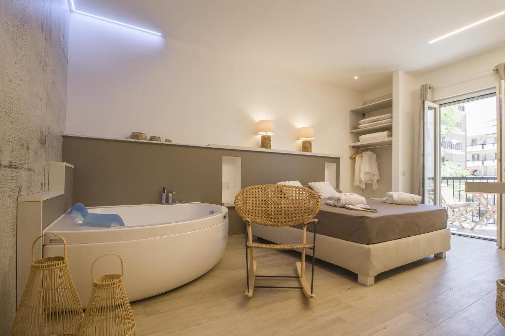 ein Bad mit einer Badewanne, einem Bett und einem Tisch in der Unterkunft Primopiano Luxury Accommodations in Vieste